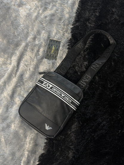 Emporio Armani EA7 black technical fabric crossbody bag featuring a branded logo tape strap and metal eagle logo