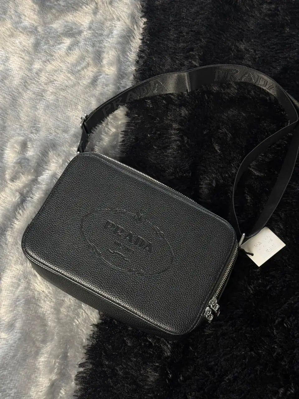Prada Glace Calfskin Crossbody bag features a signature embossed logo and an adjustable strap