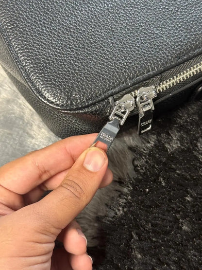 Prada Glace Calfskin Crossbody bag features a signature embossed logo and an adjustable strap